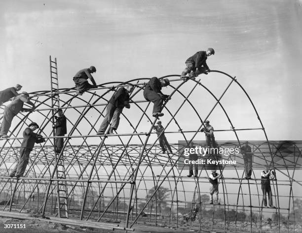 Royal Engineers and civilians work together, building the steel frames for Iris huts on a building site in Derbyshire, as part of work to build new...