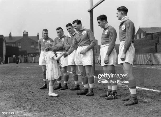 Doreen Stephenson hands a rose to Captain of the Salford team Gus Risman at Salford's rugby ground.