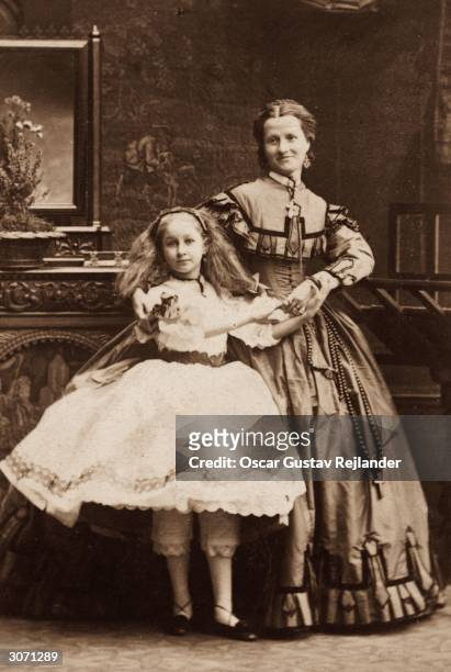Young girl and an older woman in Victorian knickerbockers and full skirts.