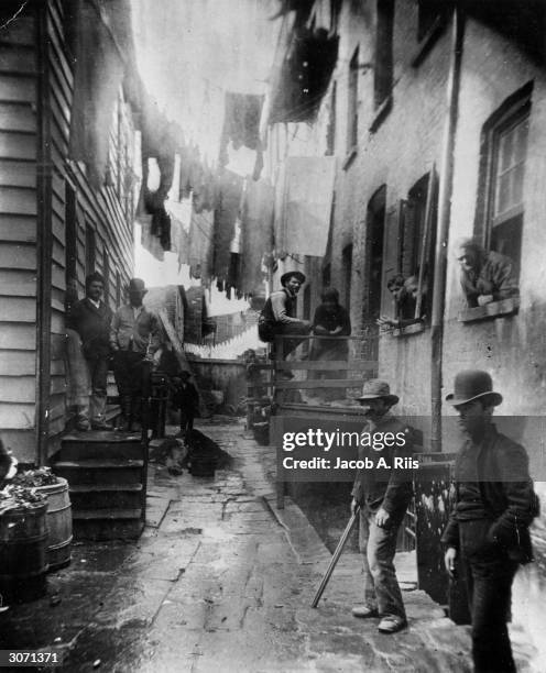 Group of men loitering in an alley known as "Bandits' Roost", situated off Mulberry Street in New York City.