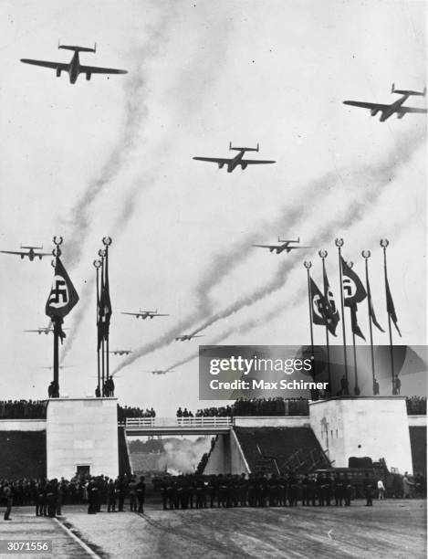 Giant bombers of the Luftwaffe leave a smoke trail as they fly over a Nuremberg rally in a show of German military might.