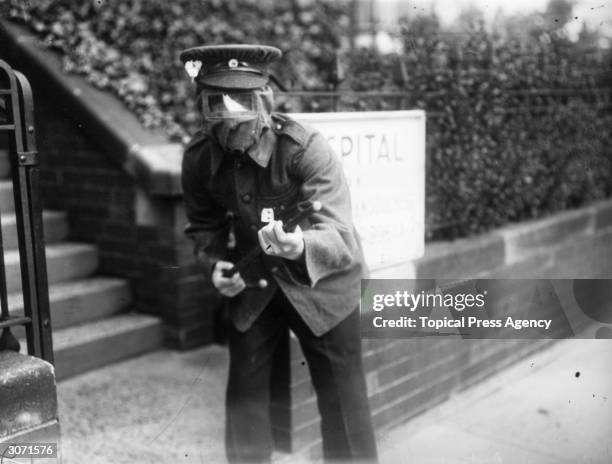 Soldier with a primitive gas mask brandishes a cane as a gun while on guard outside a hospital, Harrogate, Yorkshire, July 1915.