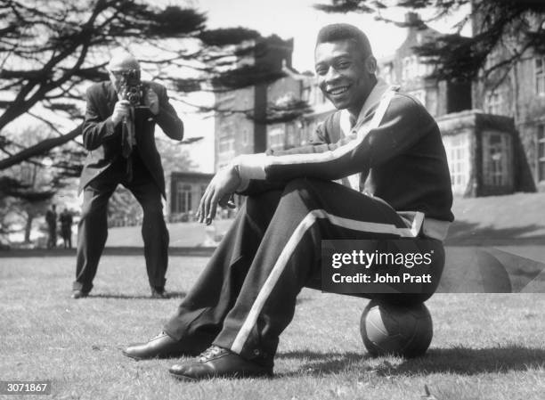 Star of the Brazilian football team, Pele sits on the ball during a break in training at Selsdon Park Hotel where they are staying. The Brazilians...