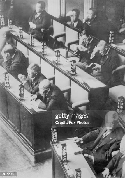Japanese parliamentarians in the House of Representatives in Japan with their names inscribed on blocks of wood which remain on the desks in front of...