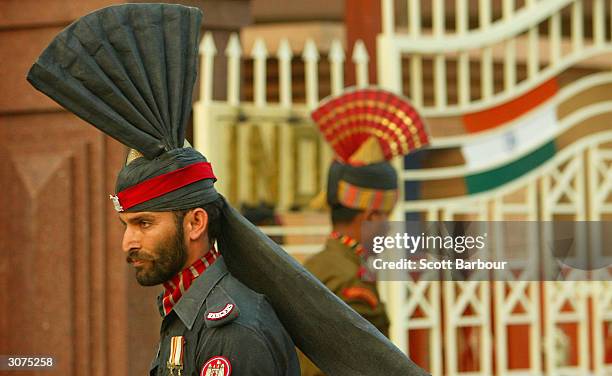 Pakistani Patan guard and an Indian Border Security force officer march during the ceremony to lower the national flags at the border crossing...