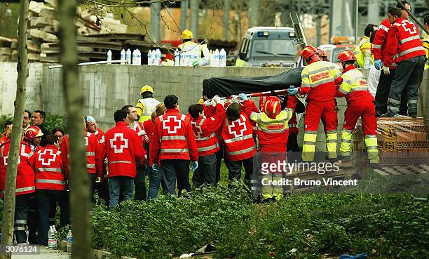 Body is lifted from the wreckage of a commuter train March 11, 2004 after it was devastated by a bomb blast during the morning rush hour in Madrid,...