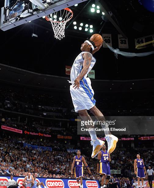 Carmelo Anthony of the Denver Nuggets goes for a slam dunk during the game against the Los Angeles Lakers at Pepsi Center on February 25, 2004 in...