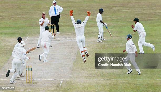 Shane Warne of Australia celebrates his 500th career wicket after dismissing Hashan Tillakaratne of Sri Lanka during day five of the First Test...