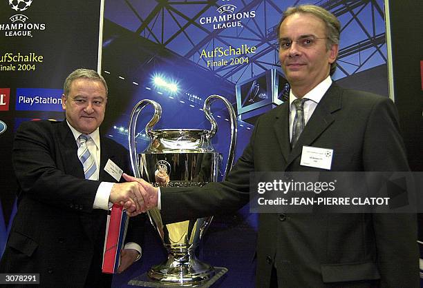 Monaco chairman Pierre Svara and Real Madrid's international director Jose Luis Lopez shake hands in front of the UEFA Champions League Cup 12 March...