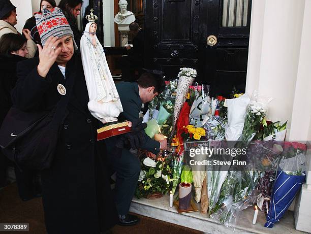 People mourn during a vigil and minute's silence held to honour the victims of the Madrid train bombings, outside the Spanish Embassy on March 12,...