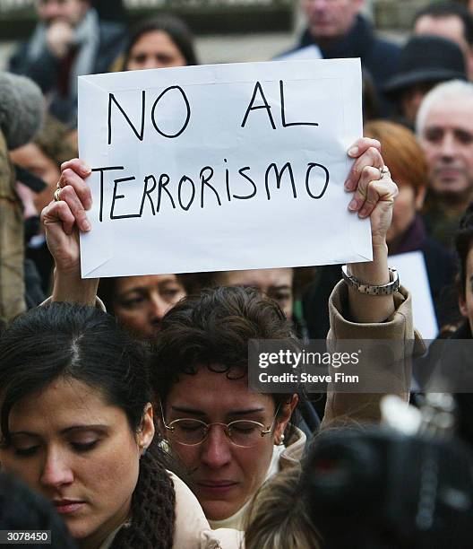 Mourner holds a sign aloft during a minute's silence held to honour the victims of the Madrid train bombings, outside the Spanish Embassy on March...