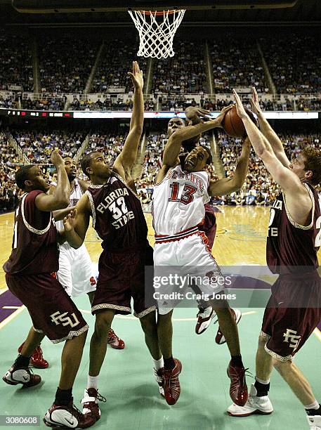 Jordan Collins of the North Carolina State Wolfpack grabs a rebound over Alexander Johnson of the Florida State Seminoles during the ACC Quarterfinal...