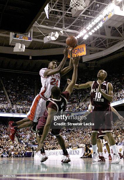 Julius Hodge of the North Carolina State Wolfpack drives over Michael Joiner of the Florida State Seminoles during the ACC Quarterfinal game on March...