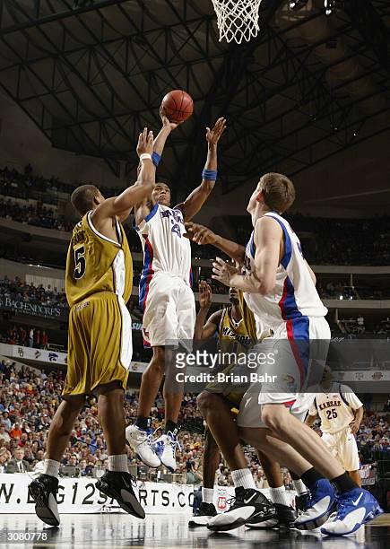 Wayne Simien of the Kansas Jayhawks shoots over Travon Bryant of the Missouri Tigers in the first half during the quarterfinals of the Phillips 66...