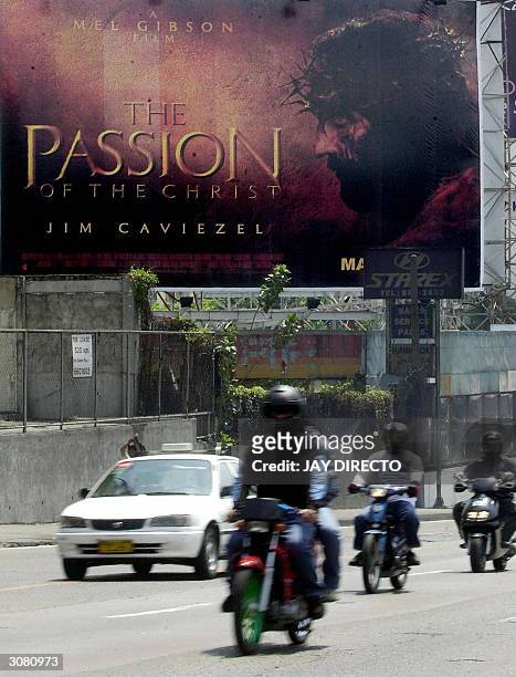 Motorists ride past a billboard advertising the controversial movie, directed by Mel Gibson "the Passion of the Christ" displayed along a street in...