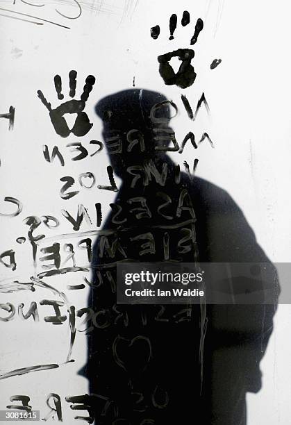 Man walks by anti-terrorism slogans painted on a window at Atocha train station March 13, 2004 in Madrid, Spain. Ten bombs exploded March 11, killing...