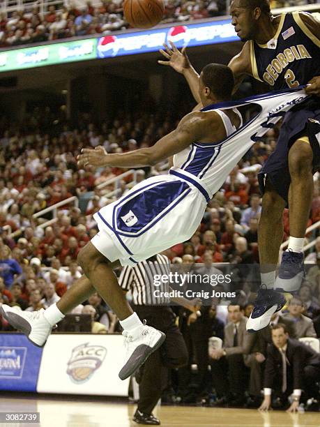 Daniel Ewing of the Duke Blue Devils is grabbed in mid air by Ismail Muhammad of the Georgia Tech Yellow Jackets during their ACC Semifinal game on...