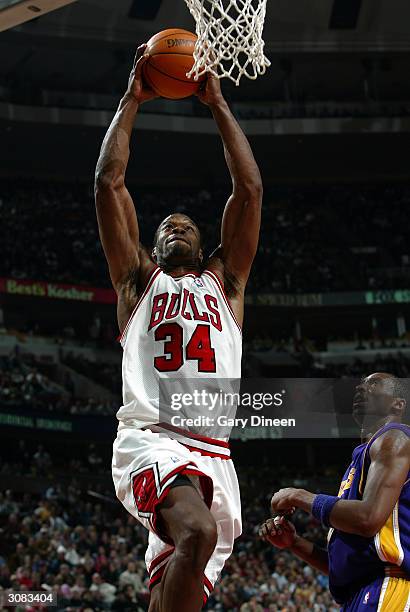 Antonio Davis of the Chicago Bulls dunks past Kobe Bryant of the Los Angeles Lakers during the fourth quarter March 13, 2004 at the United Center in...