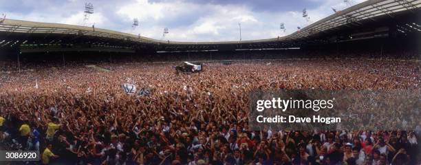 Crowds at the Live Aid concert at Wembley Stadium, some waving U2 banners, 13th July 1985.