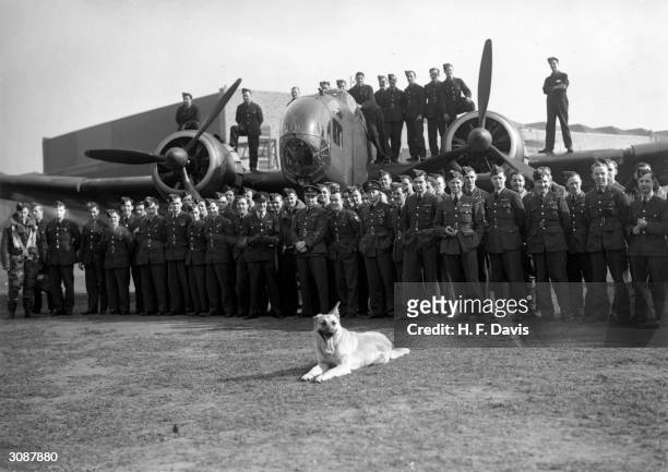 Pilots and flight crews of No 50 Squadron parade with their Handley Page Hampden bomber aircraft and dog mascot after the raid on enemy shipping off...
