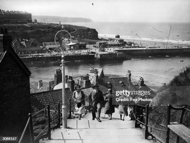 Visitors climb the 199 steps at Whitby in Yorkshire to get a better view of the town .