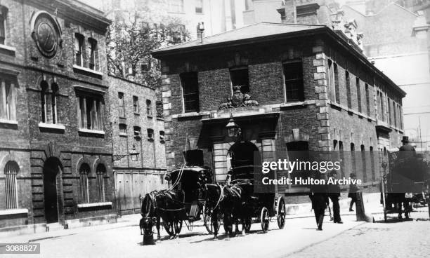 On the left, Scotland Yard, in the centre with horse drawn cabs outside is the Public Carriage Office.