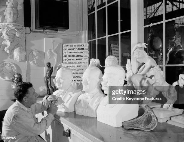 Sculptor in the Warner Brothers Plaster Shop works on the busts of Winston Churchill, Roosevelt and Joseph Stalin.