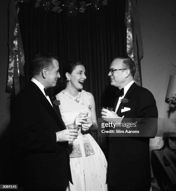 American film and theater producer Leland Hayward and his wife Slim , chatting with publisher Gardner Cowles Jr. At a New Year party on New York's...
