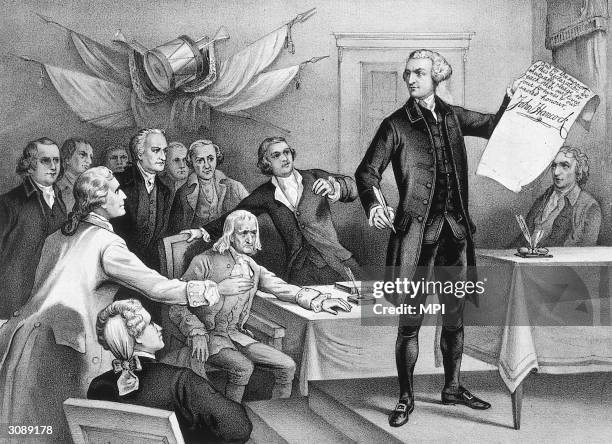 John Hancock , president of the Continental Congress is the first to put his signature to the Declaration of Independence, watched by fellow patriots...