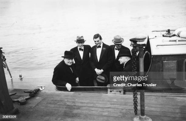 British Prime Minister Winston Churchill , on a launch leaving Westminster Pier, with American politicians Harry Hopkins , John Winant and William...