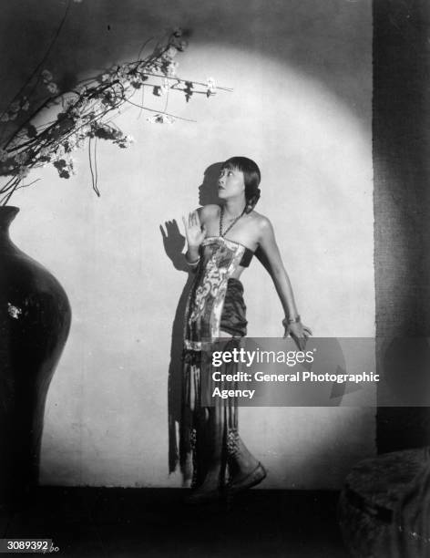 Chinese-American actress Anna May Wong surrounded by ominous shadows.