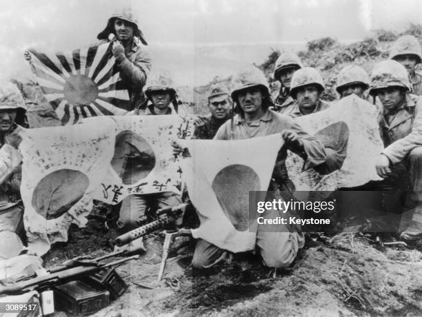 5th Division Marines display Japanese battle flags captured in the battle at Iwo Jima. The US Army landed on Iwo Jima 19th February 1945.