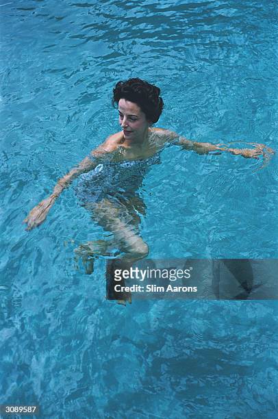 Gloria Guinness enjoying a swim in her pool at Manalapan, Palm Beach, Florida. A Wonderful Time - Slim Aarons