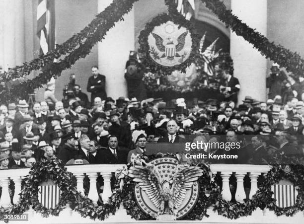 Franklin Delano Roosevelt making his inaugural address as 32nd President of the USA. Beneath his is the American symbol of an eagle with its wings...