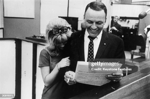 Frank Sinatra sharing a joke with his daughter, Nancy during a joint recording session in Hollywood.