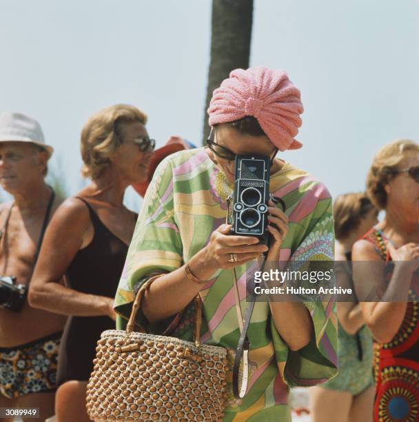 Princess Grace of Monaco taking a photograph at a swimming competition at Palm Beach, Monte Carlo.