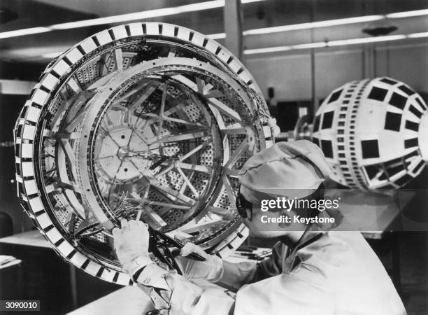 Technician prepares to wire together the components of the Bell System's Telstar experimental communications satellite, shortly before its launch...