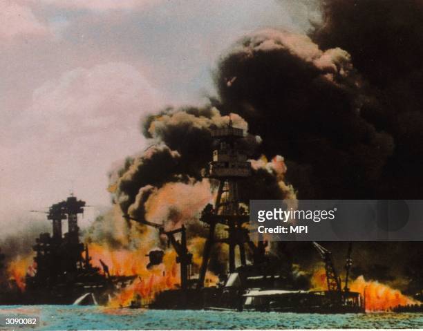 Black smoke and flames pour out of a battleship on fire in Pearl Harbour , Oahu Island after a surprise attack by the Japanese which brought America...