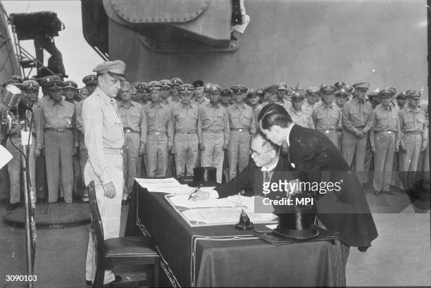 Japanese Minister of Foreign Affairs Mamoru Shigemitsu, signs the Japanese Instrument of Surrender aboard the USS Missouri in Tokyo Bay at the end of...