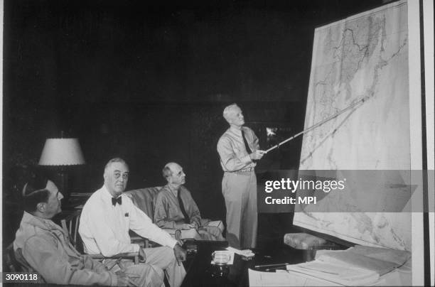 President Franklin Delano Roosevelt conferring with l to r; General Douglas MacArthur , Admiral William D. Leahy and Admiral Chester Nimitz who is...