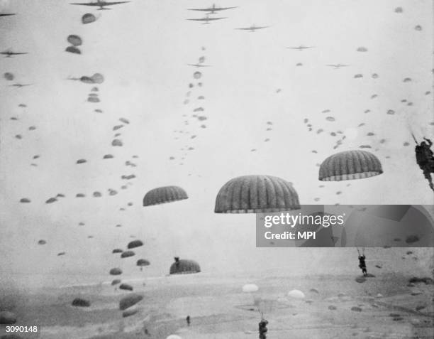 Parachutes open overhead as waves of paratroops land in Holland during operations by the 1st Allied Airbourne Army.