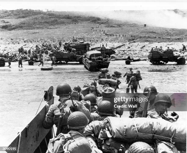 American assault troops land at Omaha Beach in Normandy supported by Naval gunfire.