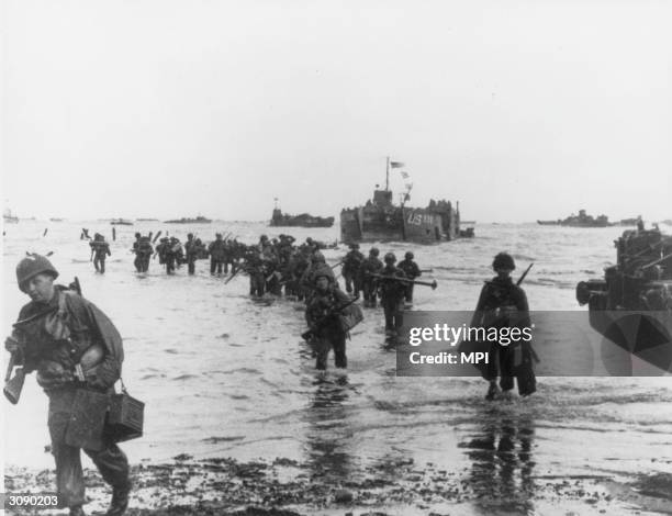 American assault troops debark from their landing craft at a beachhead on D-Day.