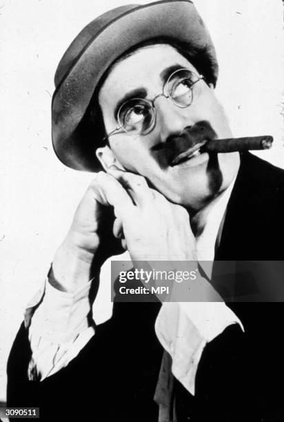 American comedian and actor Groucho Marx whose cigar and moustache became his legendary trademark.