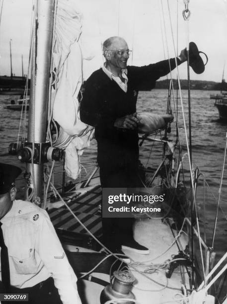 English yachtsman Sir Francis Chichester waving from the deck of the Gypsy Moth IV on his arrival in Sydney after the first solo circumnavigation of...