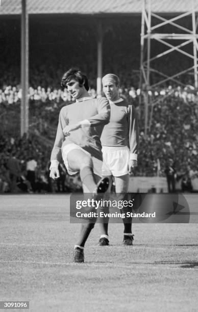 Manchester United's George Best on the football field with Bobby Charlton behind him.