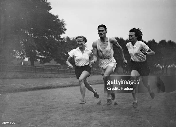 Three South African athletes high jumper Marjorie Clark, J Luckhoff and hurdler Barbara Burke in training at Paddington Recreation Ground, London,...