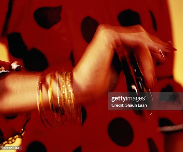 flamenco dancer's hand holding castanets,red dress behind,blurred - castanets stock pictures, royalty-free photos & images