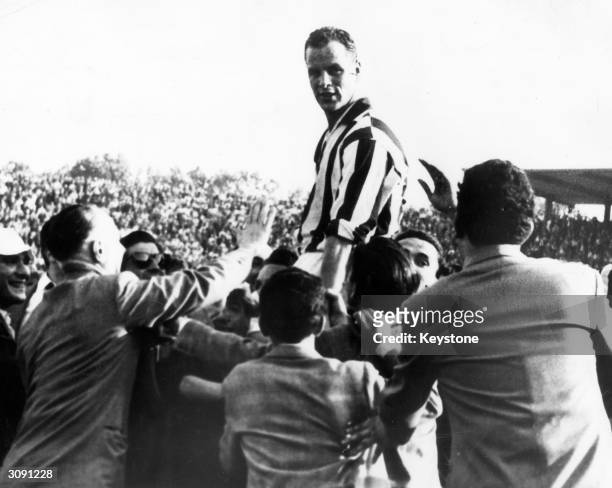 Welsh footballer John Charles is held aloft by supporters after he led his team Juventus to victory in the Italian Cup at Turin.
