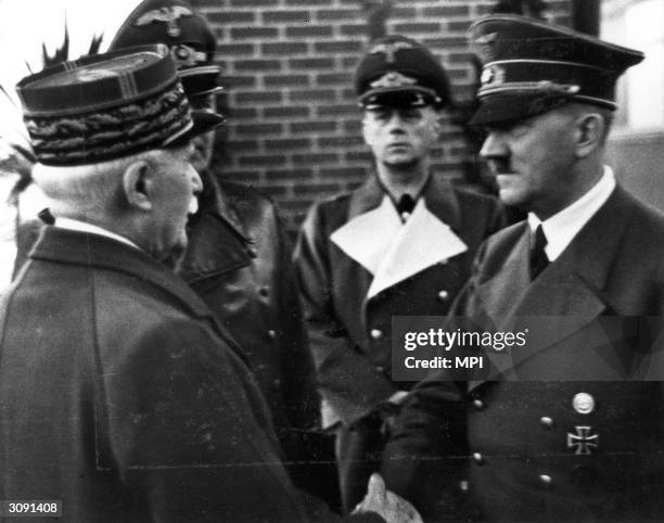 French Marshal and Vichy leader Henri-hilippe Petain shaking hands with Adolf Hitler after the fall of France, October 1940. Behind them is German...